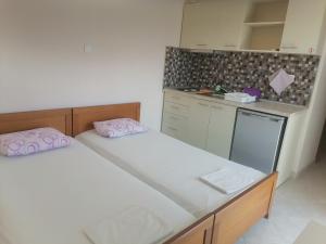 a small kitchen with two beds in a room at KALIPSO STUDIOs in Nikiti