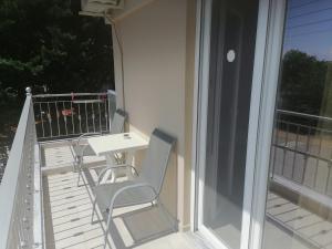 a balcony with a white table and chairs on it at KALIPSO STUDIOs in Nikiti