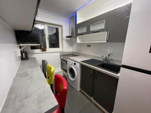 a small kitchen with a sink and a washing machine at Newly refurbished modern 2 bedroom flat in Trimley Heath