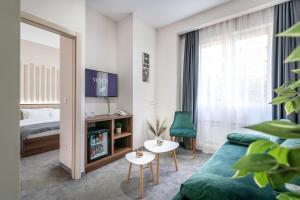 une chambre d'hôtel avec un canapé et un lit dans l'établissement Veneti Suites, à Belgrade