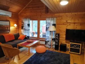a living room with a couch and a table and a tv at Casa di Sanna in Orimattila