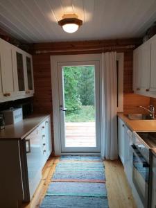 a kitchen with a door leading to a yard at Casa di Sanna in Orimattila