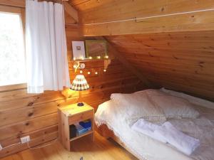 a bedroom with a bed and a table with a lamp at Casa di Sanna in Orimattila