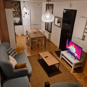 a living room with a couch and a table with a tv at SAINT DENIS PARIS STADE de FRANCE DISNEY in Saint-Denis