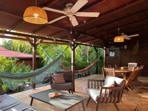 un patio con hamaca, mesa y sillas en GWO CAILLOU - Gites créoles de charme, en Bouillante