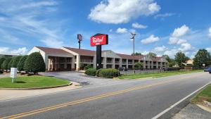 a sign for a hotel on the side of a road at Red Roof Inn Perry in Perry