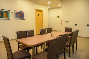a conference room with a wooden table and chairs at AQUA INN Hotel in Kinshasa
