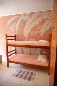 two bunk beds in a room with leaves painted on the wall at Oca Delfim in Delfim Moreira