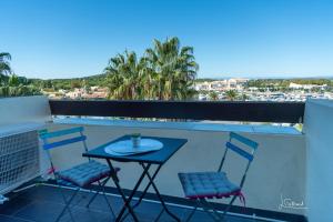 Una mesa y dos sillas en un balcón. en Studio DIAMANT naturiste, en Cap d'Agde