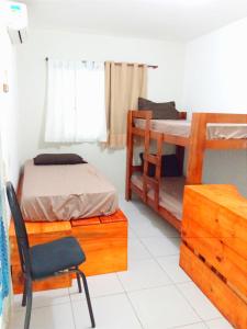 1 dormitorio con 2 literas y 1 silla en La Perla en Pipa
