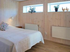 a bedroom with a white bed and two windows at Holiday home HENÅN VIII in Henån