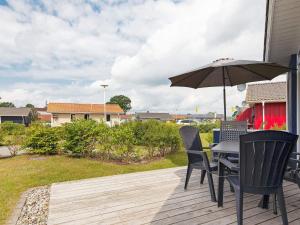 einen Tisch und Stühle mit einem Sonnenschirm auf einer Terrasse in der Unterkunft 4 person holiday home in GROEMITZ in Grömitz