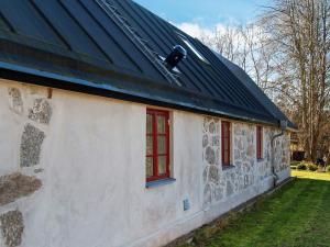 un edificio con ventanas rojas y techo negro en 4 person holiday home in SKURUP, en Skurup