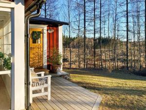 un porche de una casa con una puerta amarilla y un banco en 7 person holiday home in HALLABRO, en Hallabro