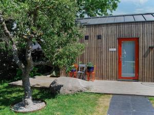 ein kleines Haus mit einer roten Tür und einem Baum in der Unterkunft 4 person holiday home in MALM in Malmö