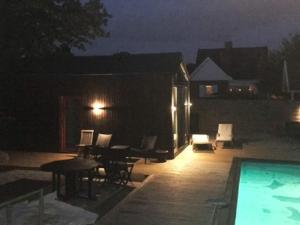 a patio at night with a swimming pool at 4 person holiday home in MALM in Malmö