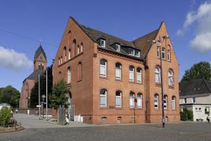 duży budynek z czerwonej cegły z wieżą zegarową w obiekcie Management - Business Suiten w Dortmundzie