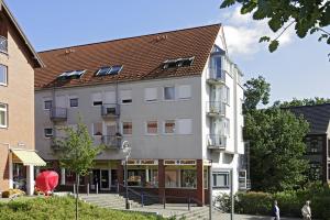 un gran edificio blanco con techo rojo en Management - Business Suiten, en Dortmund