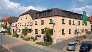 un grand bâtiment avec des voitures garées devant lui dans l'établissement Hotel Gasthof Vogelsang, à Zellingen