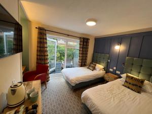 um quarto de hotel com duas camas e uma cadeira em The Chainbridge Hotel em Llangollen