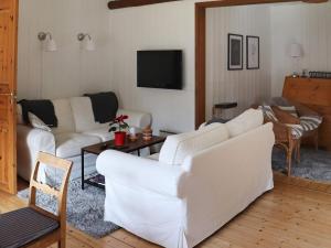 a living room with two white couches and a tv at Holiday home MUNKA-LJUNGBY III in Munka-Ljungby