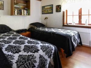 1 dormitorio con 2 camas y mantas blancas y negras en Holiday home TIBRO, en Tibro