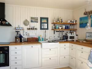 uma cozinha com armários brancos e uma bancada em Holiday home Tanumshede IX em Tanumshede