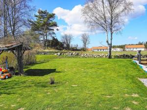 un campo de hierba con un rebaño de ovejas en el fondo en 5 person holiday home in K LLEK RR, en Spjärr