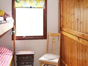 ein Schlafzimmer mit einem Etagenbett, einem Fenster und einem Stuhl in der Unterkunft Holiday home KNÄRED in Knäred