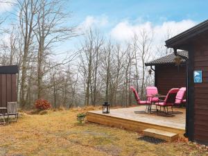 una terraza con sillas rosas y una mesa en una cabaña en Holiday home KNÄRED, en Knäred