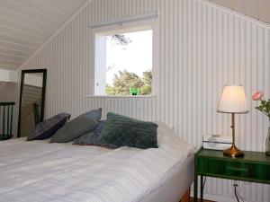 a bedroom with a white bed with a window at Holiday home OSKARSHAMN II in Oskarshamn