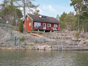 a red house on the shore of a body of water at Holiday home OSKARSHAMN II in Oskarshamn