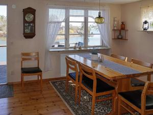 a dining room with a table and chairs and a clock at Holiday home OSKARSHAMN II in Oskarshamn