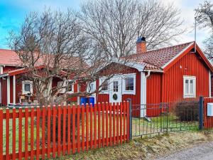 ein rotes Haus mit einem Zaun davor in der Unterkunft Holiday home BORLÄNGE in Borlänge