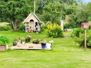 a garden with a small house with flowers in it at 9 person holiday home in K LARNE in Kälarne