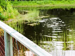 a wooden rail next to a body of water at 9 person holiday home in K LARNE in Kälarne