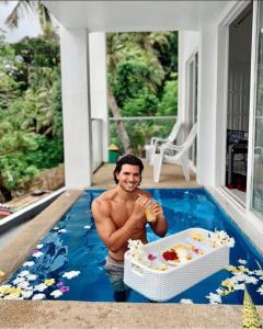 a man in a swimming pool with a box of food at Bintana Sa Paraiso in Mambajao