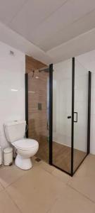 een badkamer met een toilet en een glazen douchecabine bij funattlv in Tel Aviv