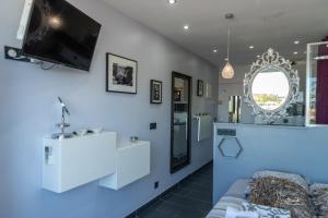 Una sala de estar con un sofá y un televisor en la pared. en Studio DIAMANT naturiste, en Cap d'Agde