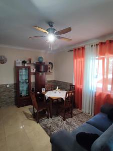 uma sala de estar com uma mesa e uma ventoinha de tecto em Casa da Pedra em Moledo