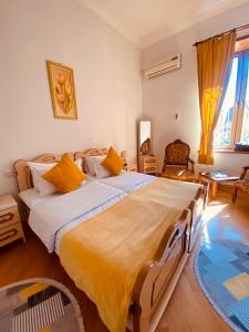 a bedroom with a large bed with yellow pillows at Hotel Tamar Mepe in Kutaisi