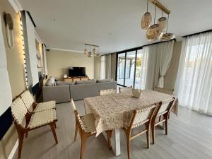 ein Wohnzimmer mit einem Tisch, Stühlen und einem Sofa in der Unterkunft Tush villa is a new, spacious, modern, cheerful in Calodyne