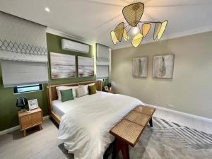 ein Schlafzimmer mit einem großen Bett und einem Kronleuchter in der Unterkunft Tush villa is a new, spacious, modern, cheerful in Calodyne