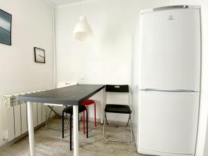 uma sala de jantar com uma mesa e um frigorífico em Стильная квартира в светлых тонах em Dnipro