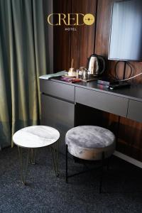 een kamer met een bureau met een tafel en een kruk bij Hotel Credo in Prizren