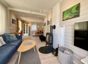 uma sala de estar com um sofá azul e uma lareira em Wildlife Panorama Lofoten em Bøstad