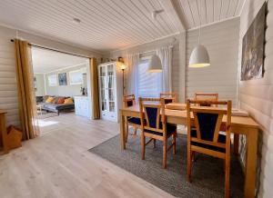 uma sala de jantar com uma mesa de madeira e cadeiras em Wildlife Panorama Lofoten em Bøstad