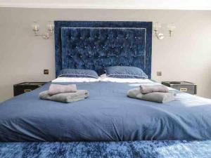 a large blue bed with two pillows on it at Bank Chambers in Bowness with Hot Tub and Lake Access in Bowness-on-Windermere