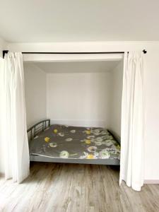 uma cama num quarto com cortinas brancas em Стильная квартира в светлых тонах em Dnipro