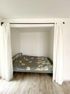 a bed in a room with white curtains at Стильная квартира в светлых тонах in Dnipro